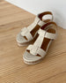 The Ally Clog in Greige leather an open t-strap sandal on a wood wedge platform. Velcro closure.Shown on wood floor.. 7