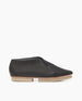 Side view of Coclico Arro Flat in Black leather: a slip-on flat with stretch leather that hugs foot, white two-part .5 inch EVA sole and a squared-off toe.  1