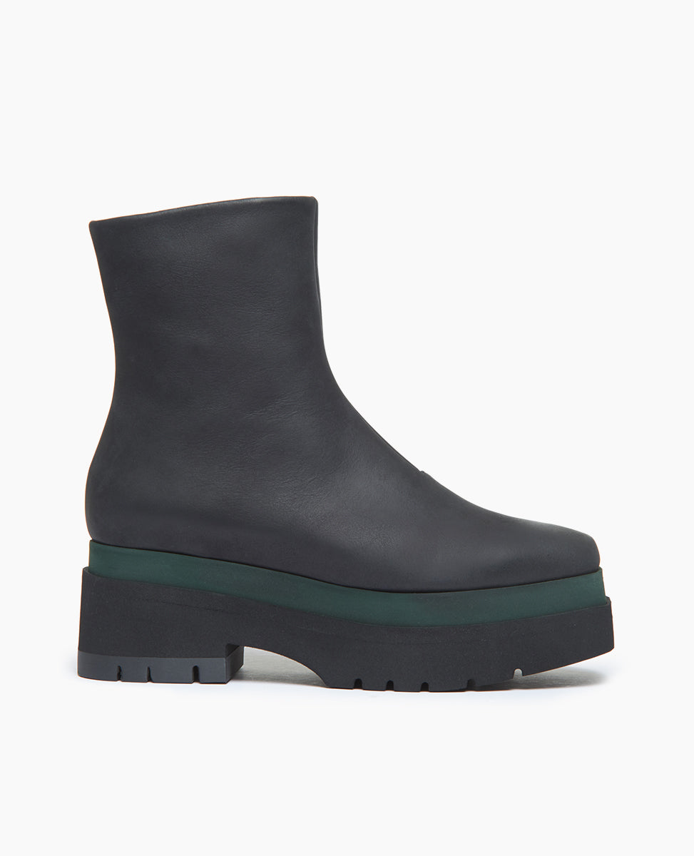 Coclico Charme Boot in Black leather: inside zip closure, angular toe, modest green platform that connects mid-height black water-resistant treated EVA soles to leather body - side view. 