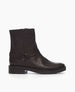 Side view of the Damiana Shearling Boot: a full shearling lined modern moto boot, featuring a belt and loop at the ankle, a lug sole, and an inside-zip closure. 1