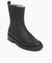 Coclico Durum Shearling Boot in black leather at an angular view. This boot features an upper updated lug sole. It is an elevated moto boot featuring an outside zip closure and a full shearling-lined interior at an angled view. 11