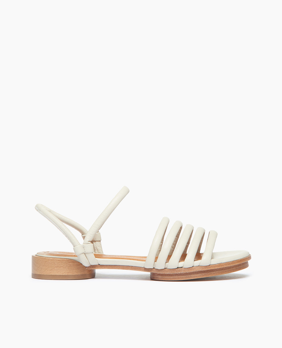 Side view of Coclico Emma Sandal in Greige nubuck: open sandal with elasticated back strap, 5 padded straps across the foot, raised two-part wood and leather sole.