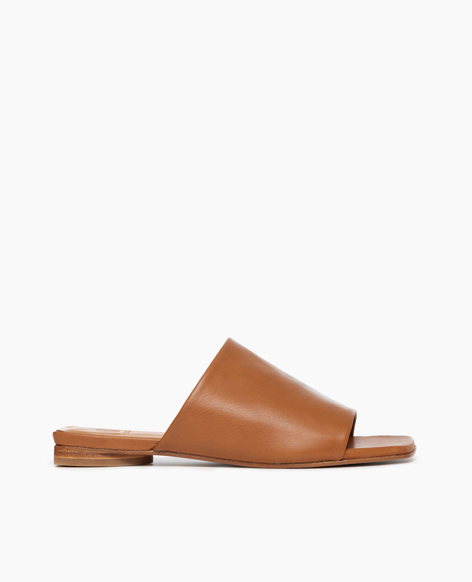 Side view of Coclico Ferhana Sandal in Cuoio leather: flat slide-on style with one solid band of leather, squared-off at the toe and heel.