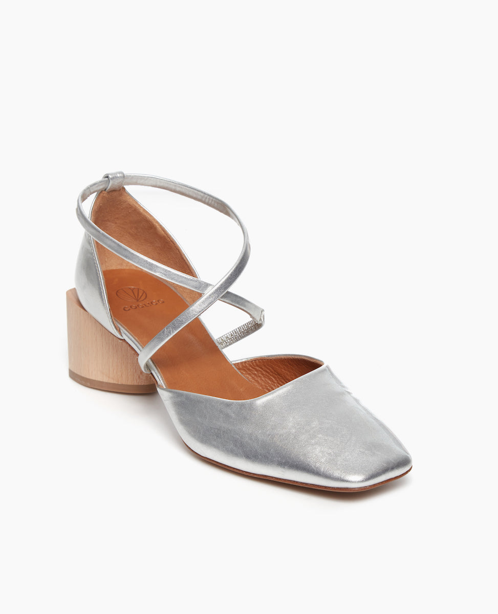 Angled view of the Isabel Mary Jane in Milky Way leather: featuring criss-cross-straps with a sculptural mid-height heel and a squared-off, angular toe character.