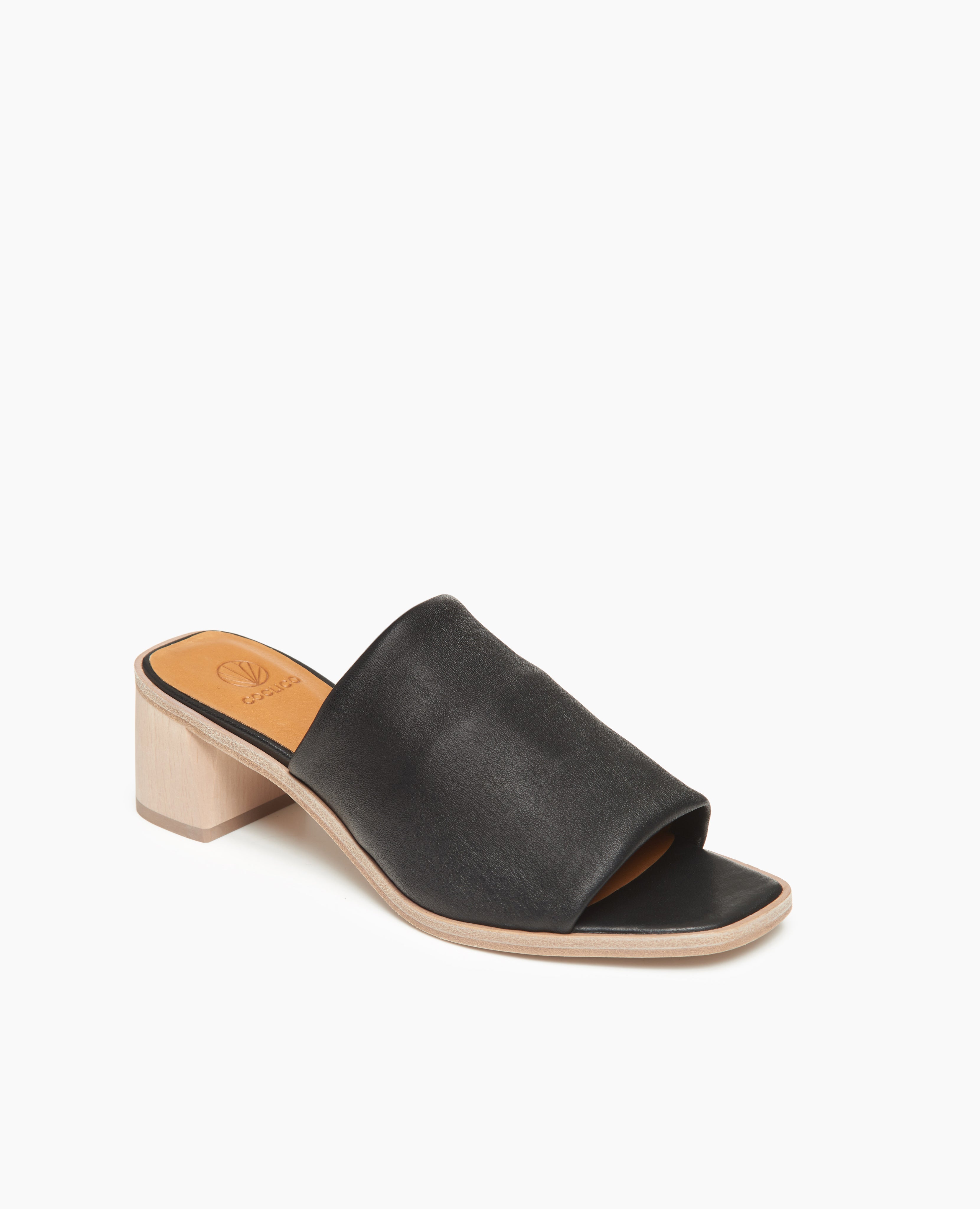 Coclico Jacque Heel in Black leather, angled view: a slide-on style with a stretch leather band across foot and a wood block mid-height heel.