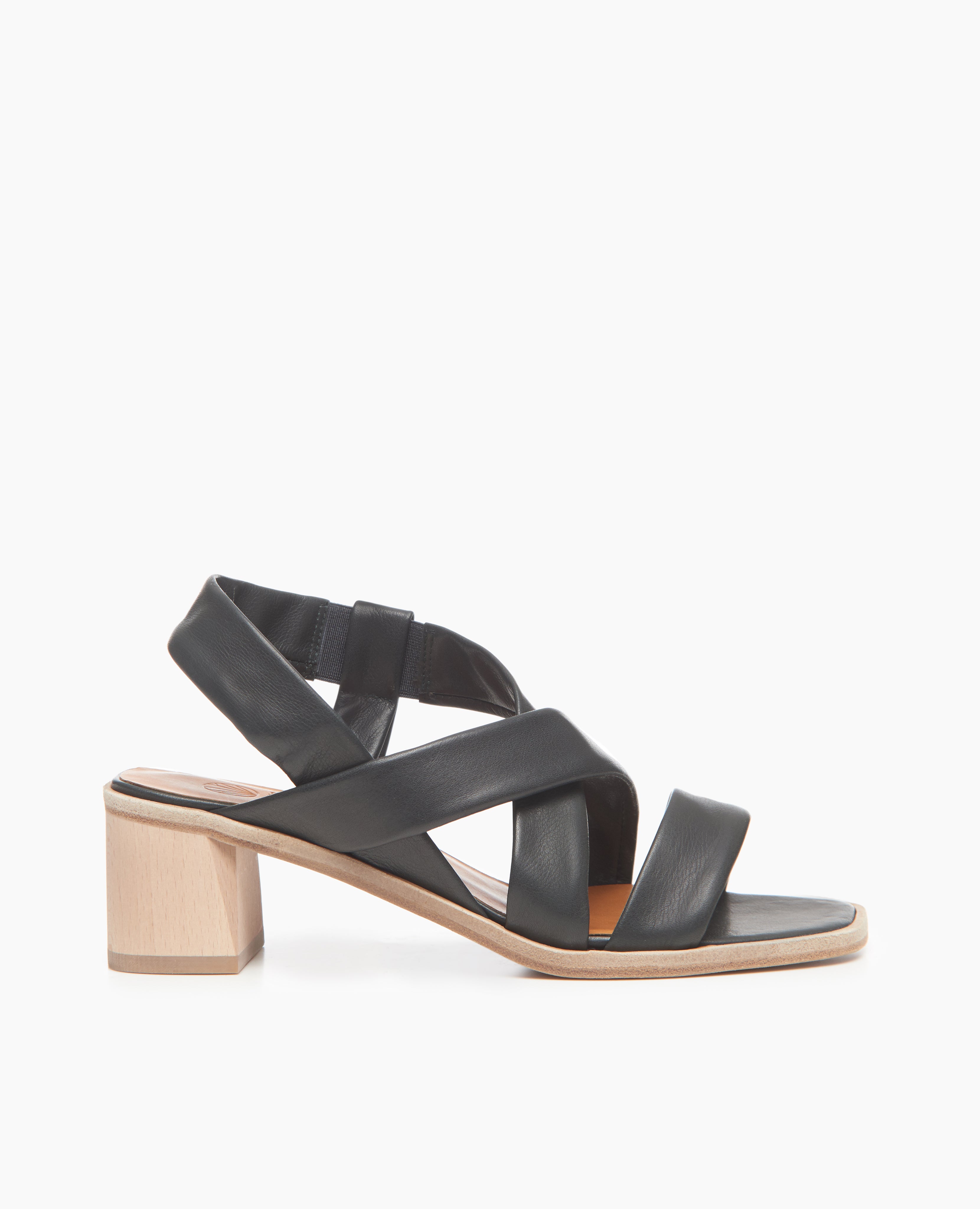 Side view of Coclico Jade Heel in Deep Sea leather: open slip on sandal with leather tube straps across the foot, ankle strap, wood block mid-height heel.