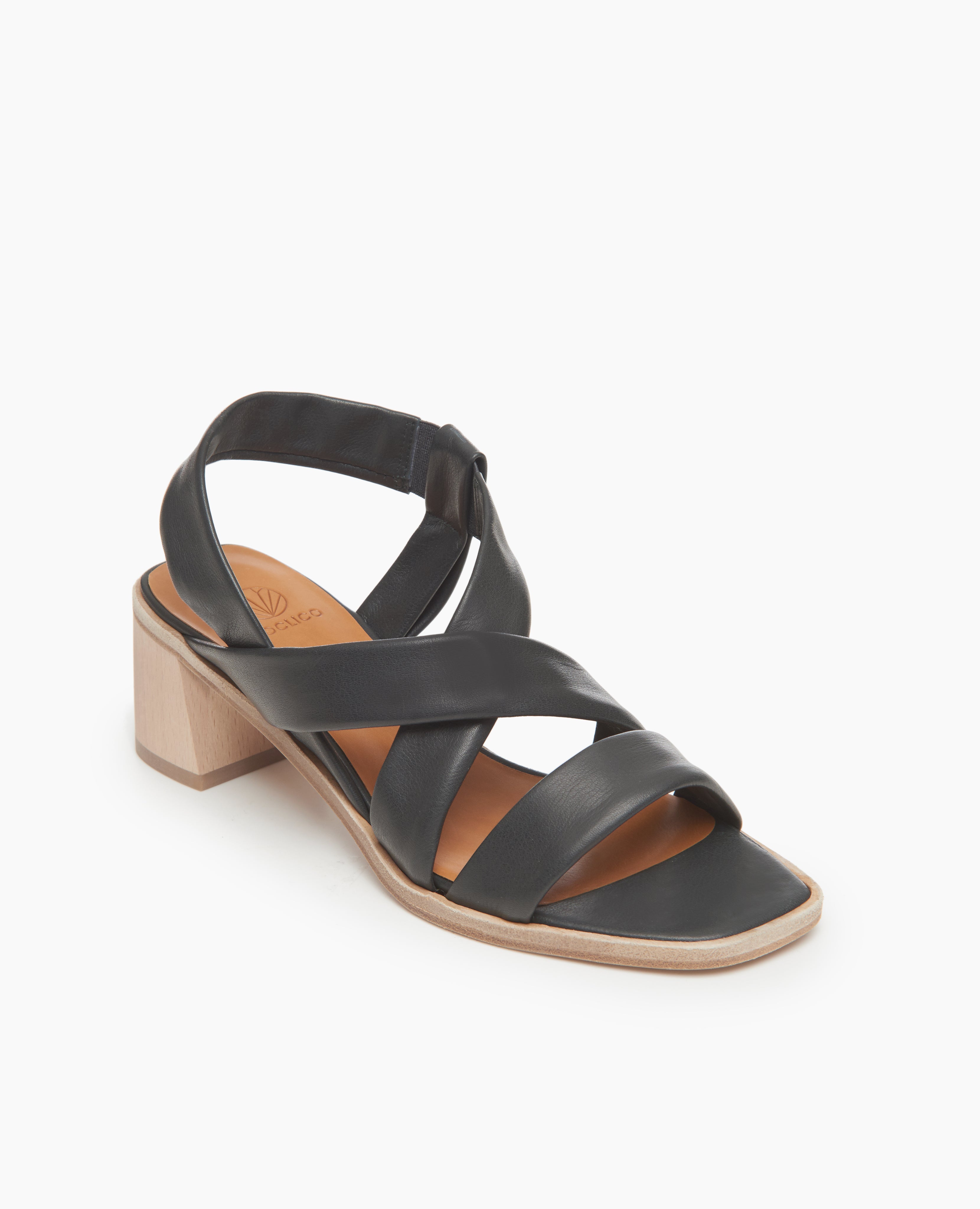 Coclico Jade Heel in Deep Sea leather, angled view: slip on sandal with soft leather tube straps across the foot, sling-back strap, wood block mid-height heel.
