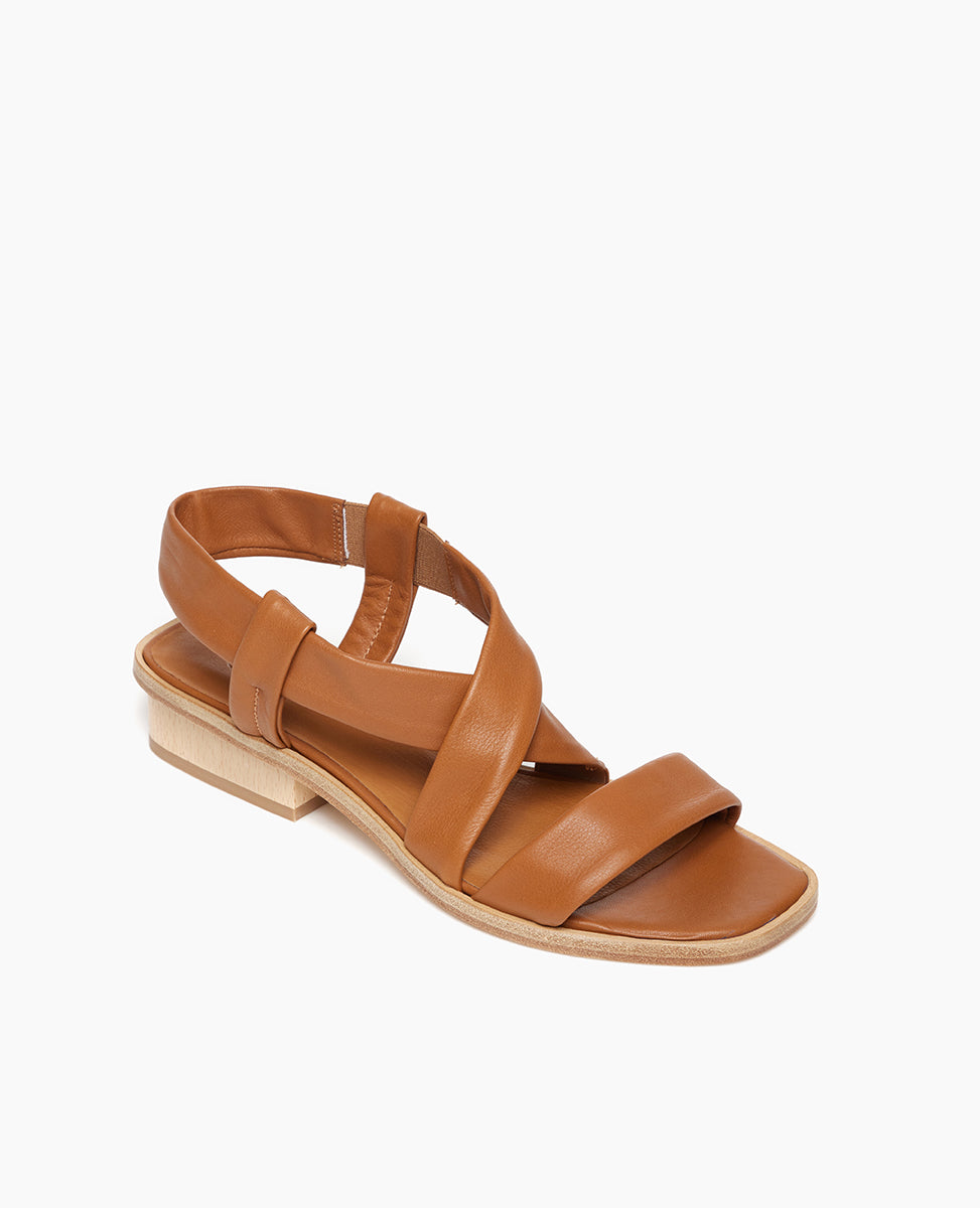 Angled view of Coclico Kestyn Sandal in cuoio leather: open sandal with tubular straps across foot and ankle, wide wood low-heel. 