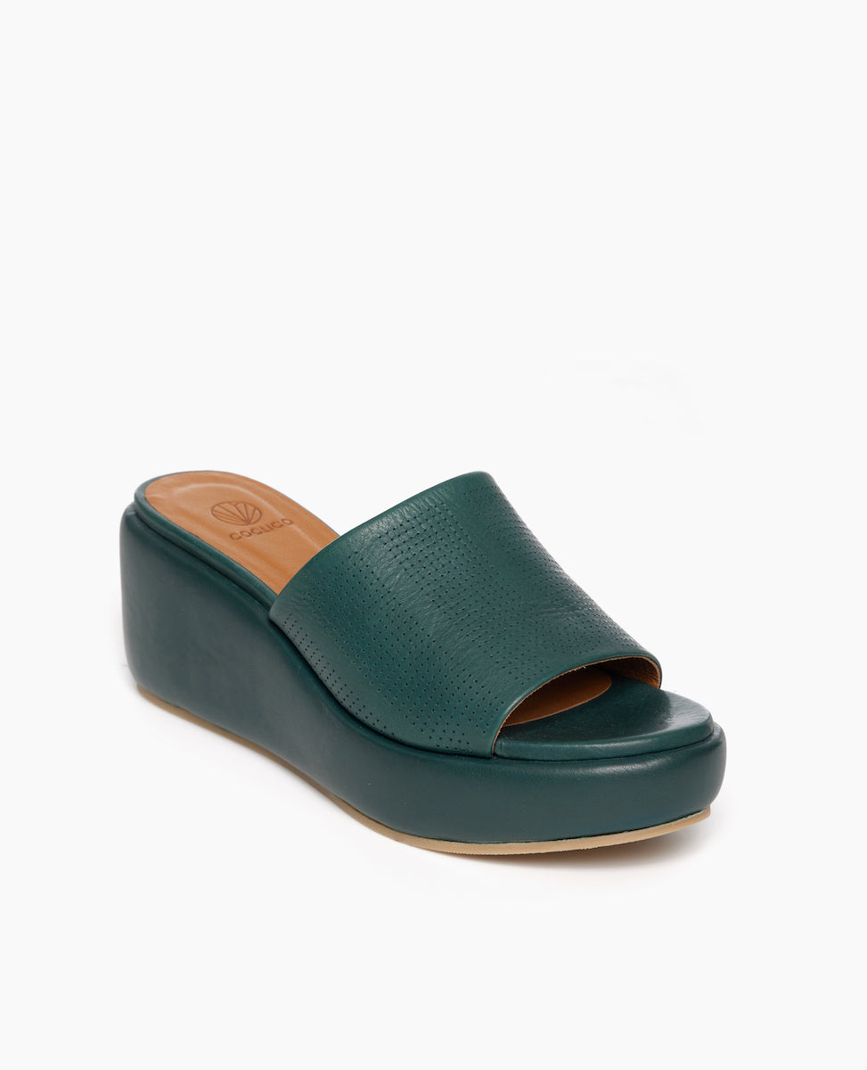Coclico Laleh Wedge in Riviera Green leather perfed, angle view: slide-on cork wedge covered in padded leather and a pinhole strap across foot. 