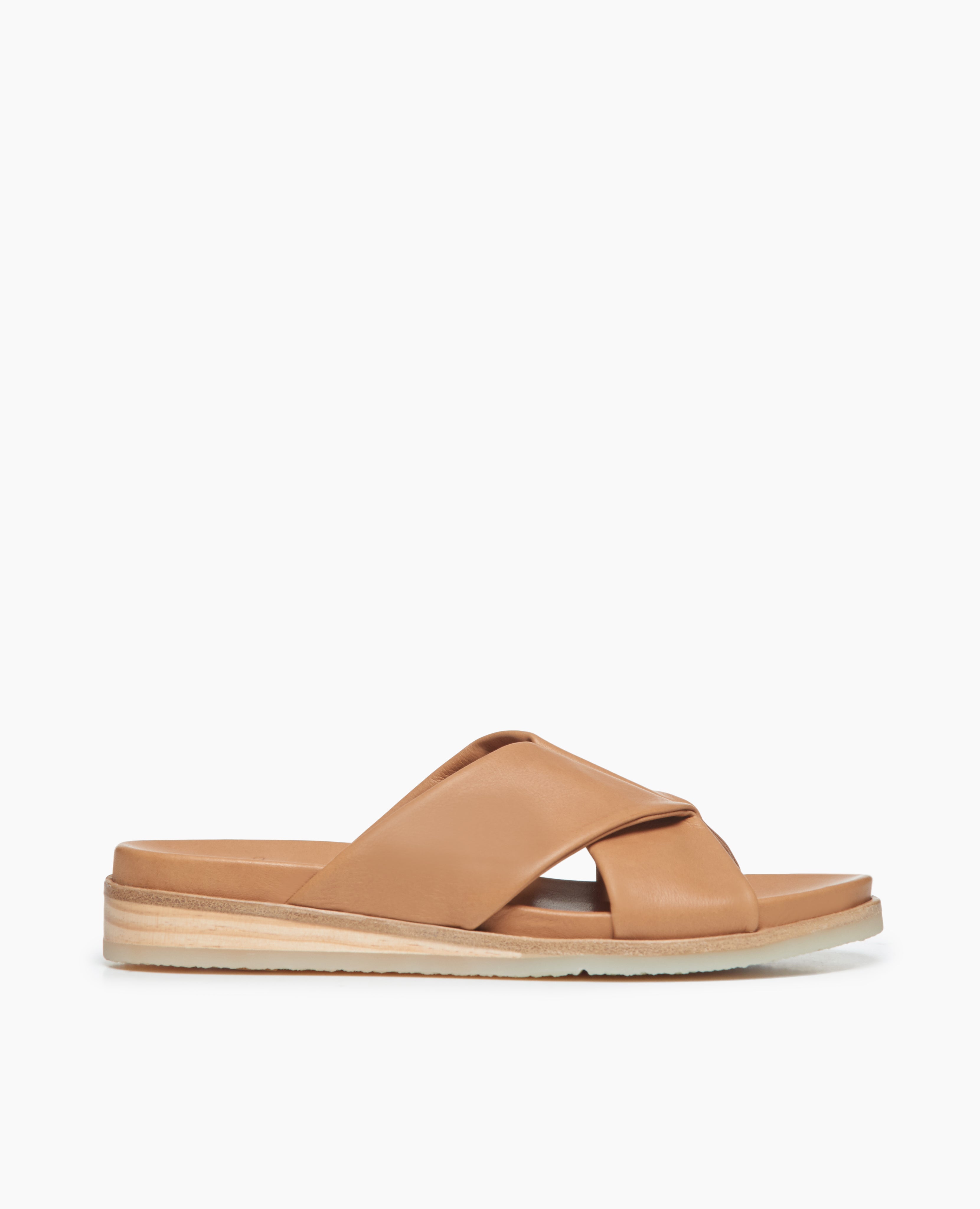 Coclico Pasque Sandal in Mandorla  leather, a low pine wedge slide sandal with gum-rubber sole and intertwined leather tube straps across foot - side view. 