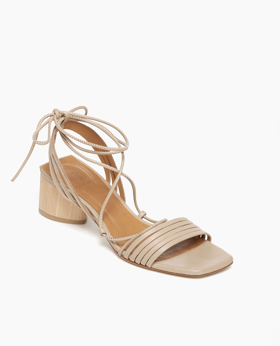 Coclico Solomiya Heel in Grey Mist leather, angle view: gladiator-style sandal with thin leather straps across vamp of foot and a low-height, solid-wood, angular heel.
