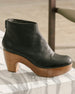 Side angled view of the Coclico Tik Clog in Black placed on a marble table.  4