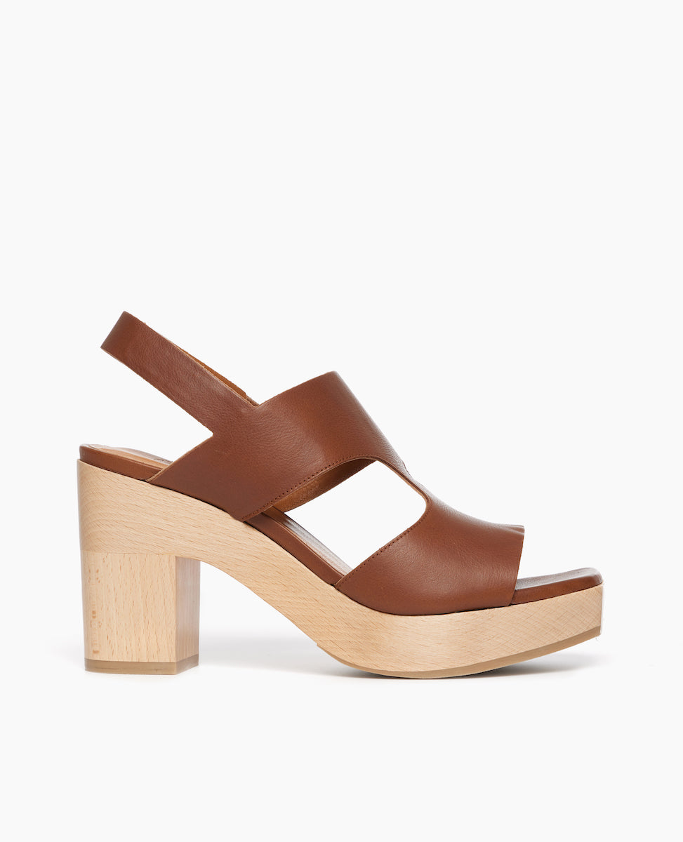 Side view of the Coclico Vicky Clog in Caramello leather: a t-straped clog, arched openings, angular toe, round heel, tall-height solid wood base.