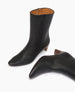 Wakame Boot in Black Leather with the left one on its side.  9