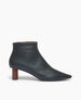 Side view of the Coclico Whoop Boot in Deep Sea leather: a timeless day-to-night ankle bootie with a pointed toe, 1.5 inch scultped solid wood heel and inside zip closure.  1