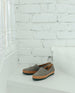 Coclico Gentian Flat in Fog nubuck : a closed toe slip-on flat with a leather band and .5 inch rubber EVA sole - placed on white staircase with white brick background. 7