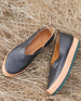 The Glace Flat in Black Leather resting on hay. 11