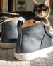 Back angled view of the Oro Sneaker in Black with a gorgeous cat in the back.  6