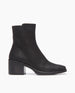 Side view of the Coclico Franna Boot in Black leather: a mid-height solid wood block black heel, stepped topline, squared-off toe, scored rubber sole and an inside zip closure.  1
