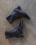 Pair of Ida Boot in Black leather against a cement floor.  5