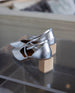 Behind view of a pair of Isabel Mary Jane shoes in Milky Way on top of a clear acrylic table.  2