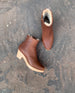 Top view shot of a pair of shearling-lined clogs with a  tapered, snipped toe, inside zip closure and mid-height wood block platform.  3