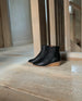 Java Boot in Black placed on the wooden floor near a wooden staircase.  8