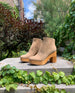 Outdoor picture of the Coclico Vida Clog in Tobacco suede on stone with greenery in background. 4