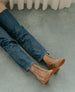 Top view of the legs of a person wearing the Bani in Tobacco, styled with jeans 5