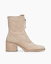 Side view of the Coclico Furin Boot in Latte nubuck, a mid-calf height boot with front zipper closure,  leather pull tab,  scored rubber sole and a mid-height solid wood block heel.  1