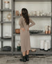 Back of woman in tabacco dress. The Durum Shearling black boot displayed from the back featuring updated upper lug sole and angled outside zip enclosure. 3