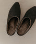 Top view of the Kera Shearling Clog in Black against a wooden backdrop.  6
