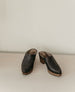 Front view of the Kera Shearling Clog placed on a wooden ground with a white backdrop. 7